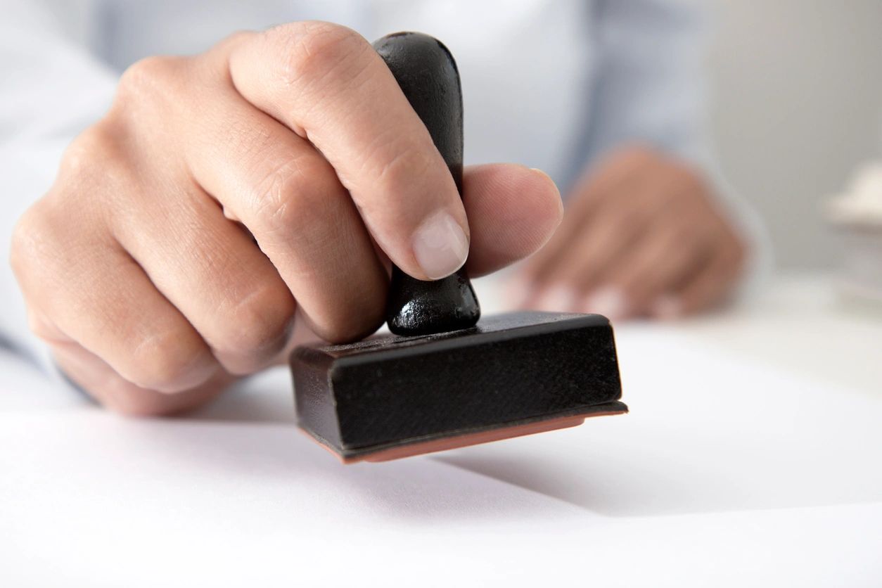 Hand holding rubber stamp for authorization